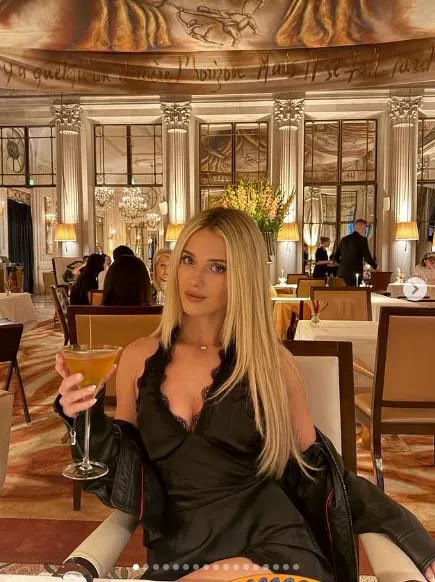 Lindsay Brewer poses for a photo holding a cocktail